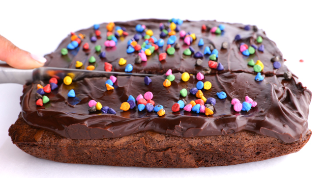 slicing brownies with rainbow sprinkles on top